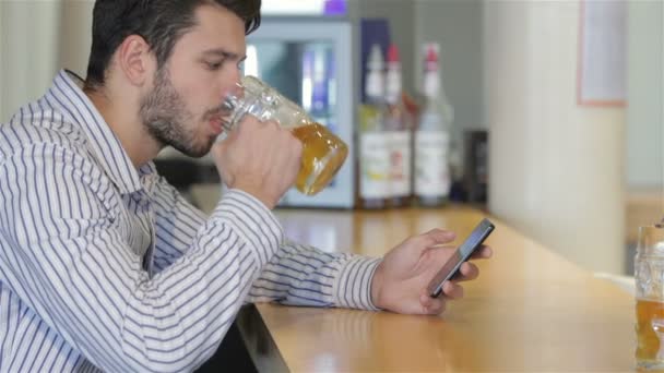 Um jovem segurando um copo de cerveja — Vídeo de Stock