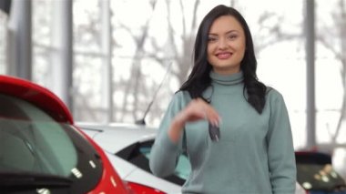 Araba anahtarı ile gülümseyen kadın
