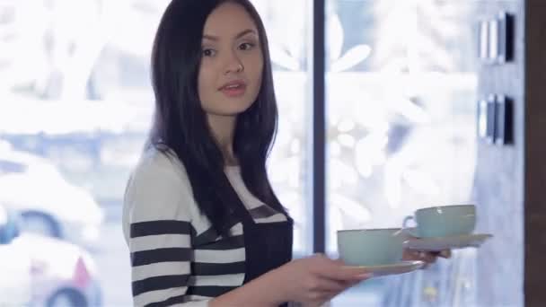 魅力的な女性バリスタがコーヒーを持ってくる — ストック動画