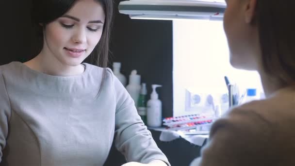 Joven mujer caucásica recibiendo una manicura — Vídeo de stock