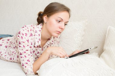 genç kadın dijital tablet üzerinde ciddi bir haber okuma