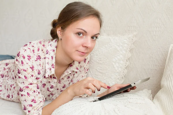 Mujer joven con dispositivo digital sonriendo en la cámara — Foto de Stock