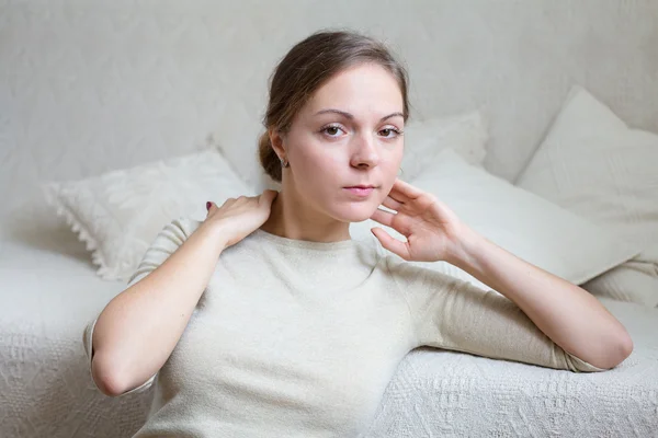 Młoda kobieta w domu dotykając jej szyi w relaks nastroju — Zdjęcie stockowe