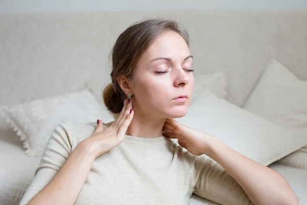 Młoda kobieta w domu dotykając jej szyi w relaks nastroju — Zdjęcie stockowe