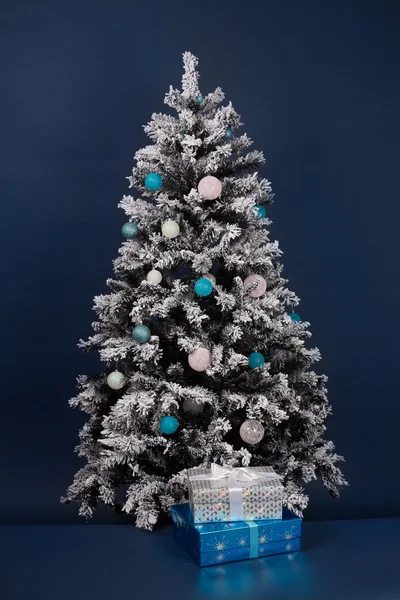 Dos cajas de regalo cerca del árbol de año nuevo sobre fondo azul oscuro Fotos de stock libres de derechos