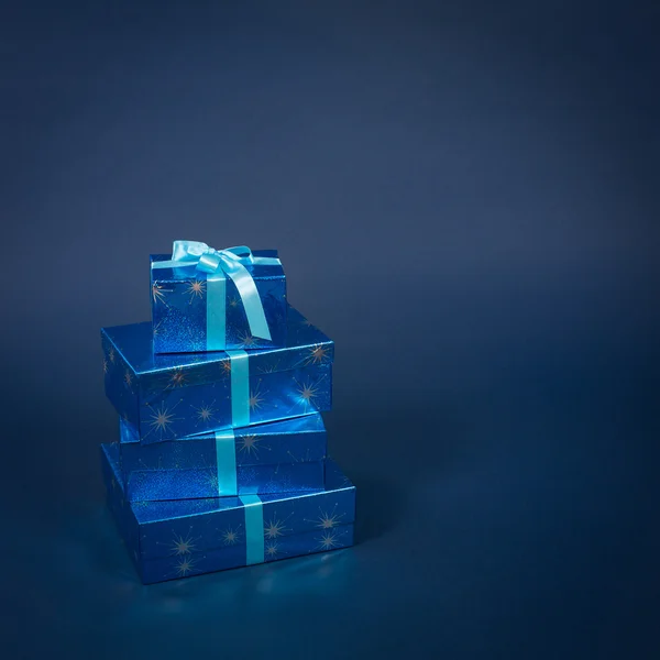Mehrere Geschenkboxen in blauen Farben auf dunkelblauem Hintergrund Stockfoto