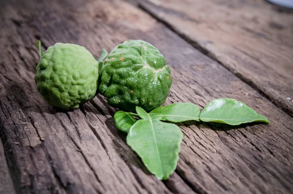 Eski ahşap arka plan üzerinde gölge bergamot ile yeşil yapraklar