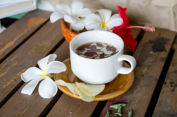 ahşap masa üzerinde Plumeria ile çay bardak