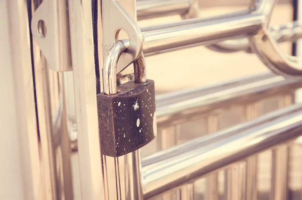 old master key locked on the basket ball stadium gate , green metal fence