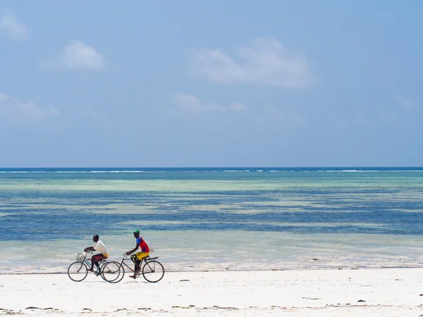 Mensen fietsen op het strand — Stockfoto