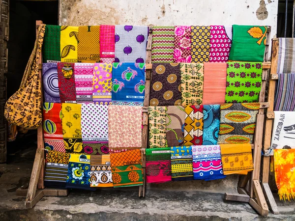 Traditionele Afrikaanse kangas en andere materialen verkocht in stone town, zanzibar. — Stockfoto