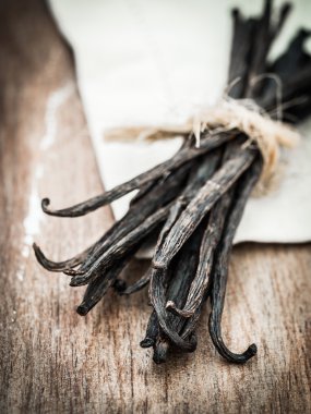 ahşap rustik masa üstünde vanilya çubukları.