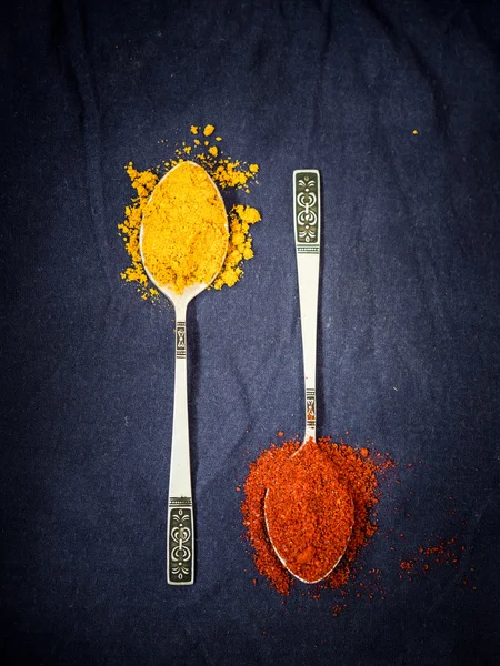 Turmeric and red paprika on silver spoons. — Stock Photo, Image