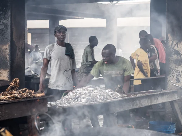 People frying fish — Stock Photo, Image