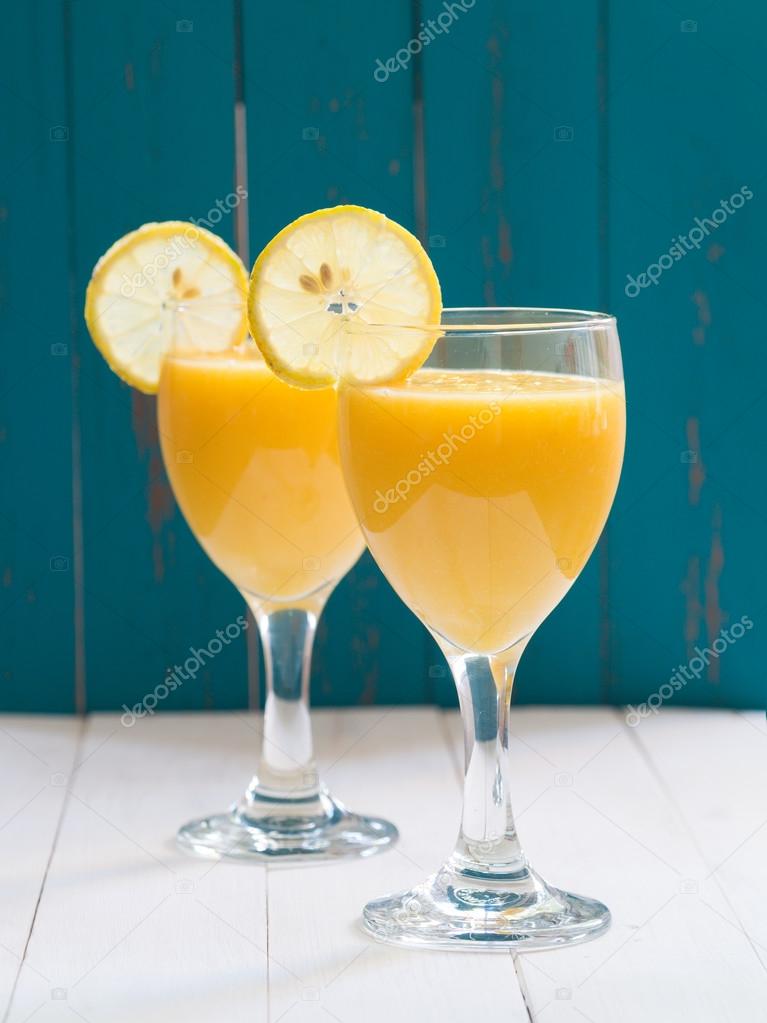 glasses of fresh yellow tropical fruit smoothie