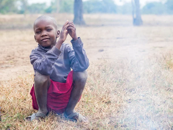 Niño masai sentado junto a un fuego — Foto de Stock