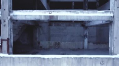 Kameranın düzgün uçuşu, terk edilmiş beton bir bina, boş pencereler ve balkonlar, kamera yükseliyor.