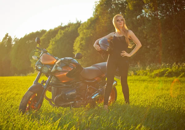 Piękna dziewczyna z motocyklem w słońcu — Zdjęcie stockowe