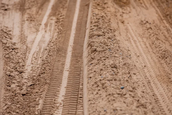 Traços de pneus no chão. Off road 4X4 rodas trilhas no país deserto praia estrada areia motoring fundo imagem — Fotografia de Stock
