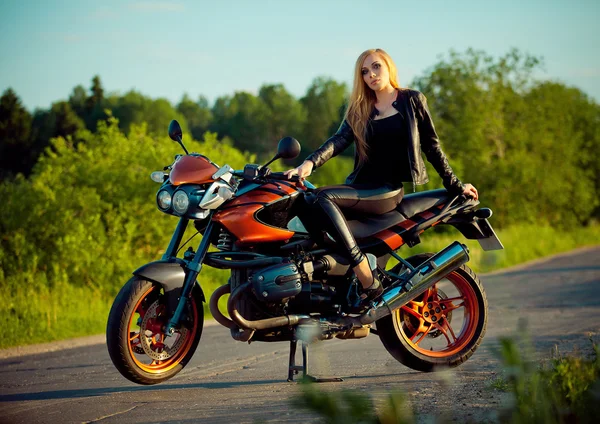 Молода сексуальна жінка сидить на червоному мотоциклі — стокове фото
