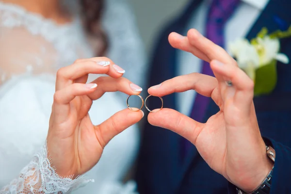 Braut und Bräutigam halten Händchen im Ring — Stockfoto