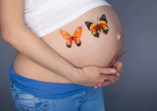 Mujer embarazada caucásica estrés ansioso con mariposa en el estómago estudio aislado sobre fondo gris — Foto de Stock