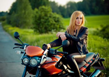 Açık moda portre genç seksi tan sarışın kadının poz güneş ışığı kırmızı scooter Bisiklet.