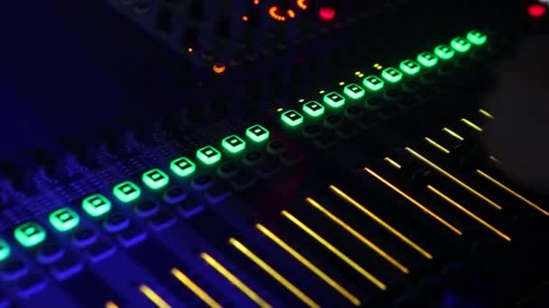 DJ profesional en el trabajo durante un espectáculo con luz intermitente. Ingeniero de sonido trabajando en un club con una consola de sonido y micrófonos — Vídeo de stock