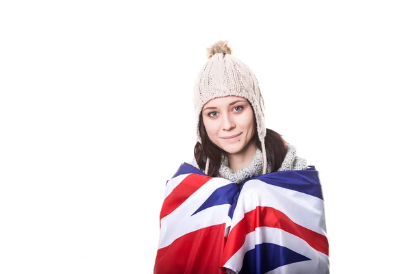 Beautiful patriotic vivacious young woman with the American flag held in her outstretched hands standing in front of an expanse of white sand — Stock Photo, Image