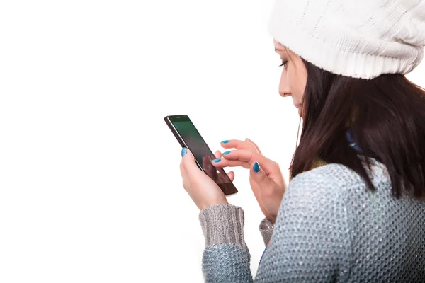 Χαμογελώντας χειμώνα Hipster κορίτσι σε πλεκτά πουλόβερ και καπέλο Beanie με κινητό τηλέφωνο που απομονώνονται σε λευκό. Εφηβική επικοινωνιακού Concept της Dunlopillo. — Φωτογραφία Αρχείου