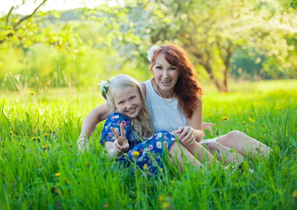Маленькая девочка и мама собирают яблоки. Портрет счастливой матери и маленькой дочери с сердцем . — стоковое фото