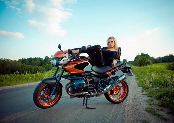 Красива дівчина з червоним мотоциклом на сонці — стокове фото