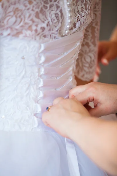 Demoiselle d'honneur attacher arc sur robe de mariée — Photo