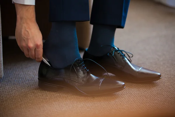 Homme d'affaires attachant des lacets de chaussures sur le sol. Gros plan . — Photo