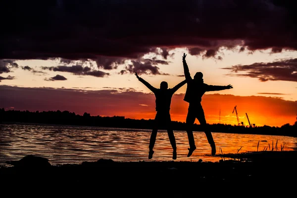 Jeune couple heureux sautant sur la plage — Photo