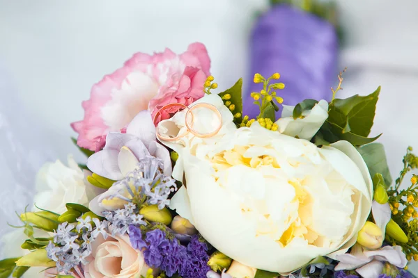 Wedding rings and roses bouquet. — Stock Photo, Image