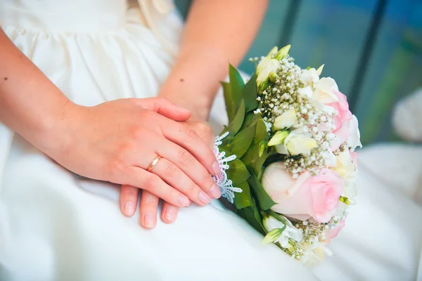 Beautiful bouquet of different colors in the hands of the bride in a white dress — Stock Photo, Image