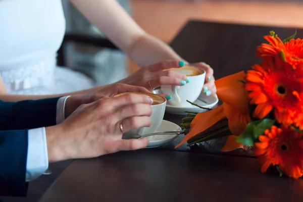Hände von Mann und Frau und Kaffeetassen auf dem Tisch — Stockfoto