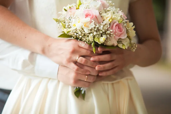 Groom and bride holding wedding bouquet — Stock Photo, Image
