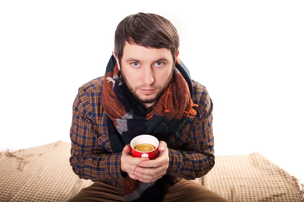 Schöner junger Mann in Winterkleidung mit einer Tasse heißem Tee. — Stockfoto