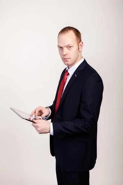 Kreativer junger Programmierer im Businessanzug mit Krawatte und Sonnenbrille präsentiert lächelnd ein Tablet. — Stockfoto