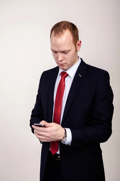 Portret van jonge zakenman met een touchscreen toestel tegen witte achtergrond — Stockfoto