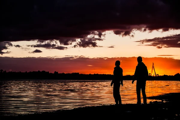 Couple heureux homme et femme marchant et se tenant la main sur une plage avec un lever de soleil coloré lumineux sur le fond, couple romantique amoureux marchant au coucher du soleil, femme et homme amoureux marchant main dans la main — Photo
