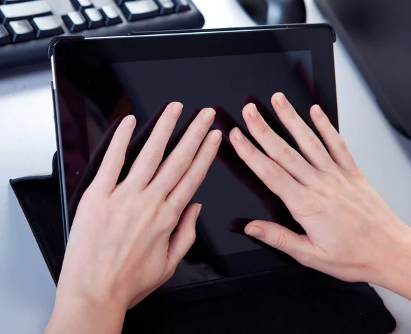 Mujer de negocios en el lugar de trabajo está trabajando en una tableta — Foto de Stock