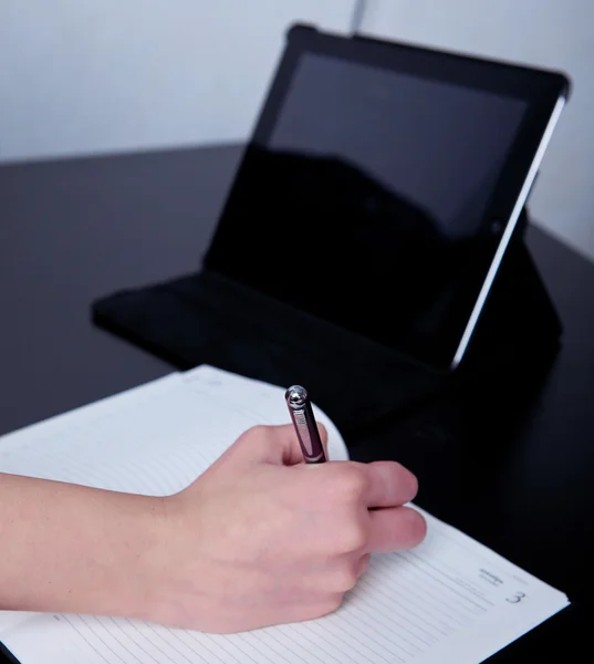 Business woman in a cafe making notes in a diary — Stock Photo, Image