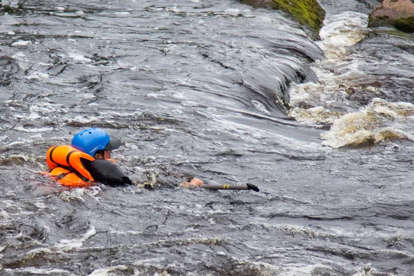 Des gens en gilets de sauvetage se noient dans une rivière turbulente Images De Stock Libres De Droits