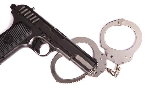 Polizeihandschellen mit Pistole auf weißem Hintergrund — Stockfoto