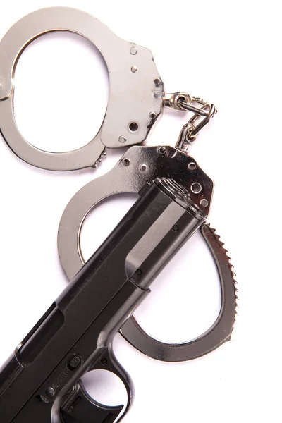 Police handcuffs with a gun isolated on a white background — Stock Photo, Image