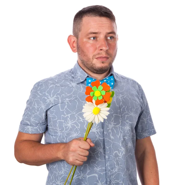 Attractive adult man with stubble in a bow tie in summer shirt holding a bouquet of flowers on isolated white background — Stock Photo, Image