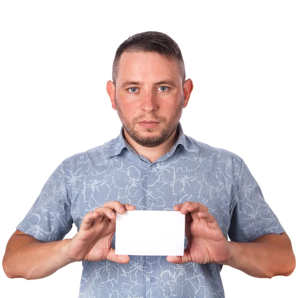 Aantrekkelijke volwassen man met stoppels in zomer shirt in zijn handen met een wit vel met ruimte voor reclame tekst op een afgelegen witte achtergrond — Stockfoto